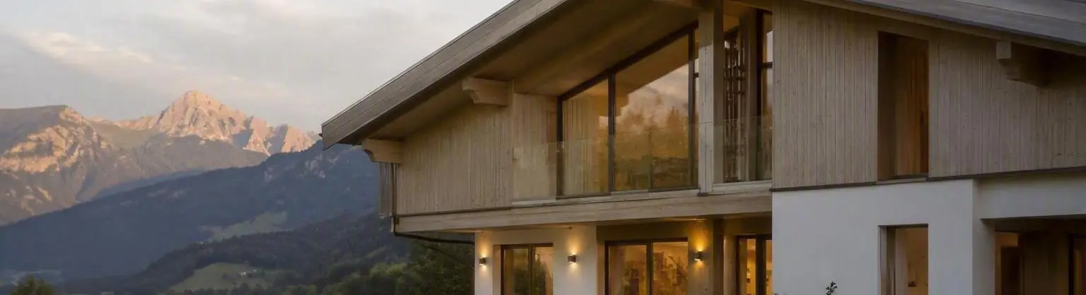 Chalet contemporain en bois face aux montagnes, au coucher du soleil